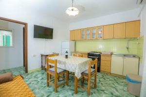 a kitchen with a table and chairs and a television at Apartmani Sime in Savar