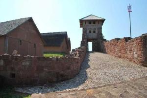 a stone wall next to a building and a tower at Ferienhaus Hofmann Hainrode in Hainrode