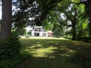a house in the middle of a yard with trees at Ferienhaus Stang in Godendorfer Teerofen