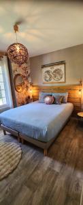a bedroom with a bed and a chandelier at Mont Joly Gîte in Soumont-Saint-Quentin