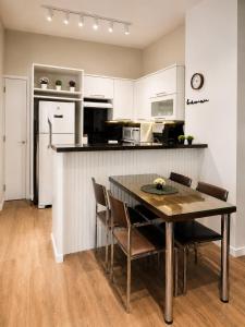a kitchen with a table and chairs and a refrigerator at Apartamento Vista Jardim in São Domingos
