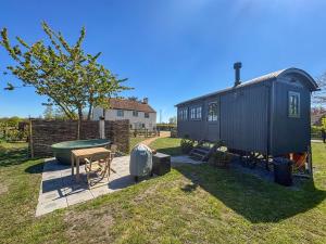a small black train car sitting in a yard at Shepherds Hut - Uk49729 in King's Lynn