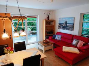 a living room with a red couch and a table at Kölp - Wald und Mee h r in Kölpinsee