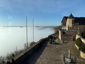 a building on the edge of a mountain with fog in the background at Ferienhaus SonnenFänger in Hemfurth-Edersee