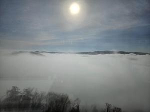a view of a fog field with the sun in the sky at Ferienhaus SonnenFänger in Hemfurth-Edersee