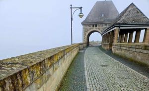 a bridge over a cobblestone street next to a building at Ferienhaus SonnenFänger in Hemfurth-Edersee +16 photos
