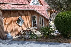 a house with a table and chairs in front of it at Ferienhaus SonnenFänger in Hemfurth-Edersee