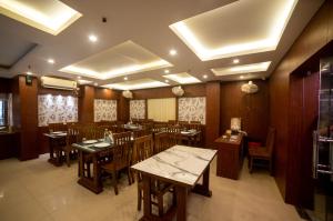 a dining room with wooden tables and chairs at Hotel Sonajhuri in New Digha