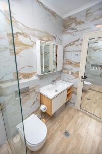 a bathroom with a sink and a toilet and a shower at Veranda White in Nea Vrasna +26 photos