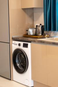a kitchen with a washing machine and a sink at Veranda White in Nea Vrasna