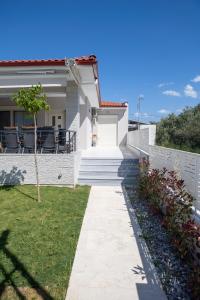 a white house with a pathway leading to the front yard at Veranda White in Nea Vrasna