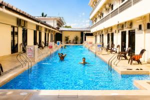 a group of people swimming in a swimming pool at Paradise Resort Langkawi in Pantai Cenang