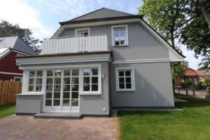 a small grey house with a large window at Haus "Fock" in Prerow