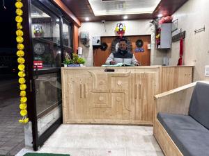 a man standing behind a counter in a store at Jai Shri Badri in Badrinath