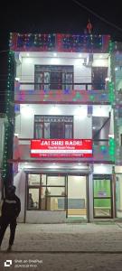 a tall white building with a red sign on it at Jai Shri Badri in Badrinath +34 photos
