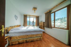 a bedroom with a bed and a large window at Rhodope House Momchil Yunak in Momchilovtsi
