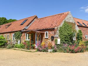 a brick house with flowers in front of it at The Old Paybarn - Uk39378 in Snettisham