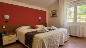 a bedroom with a bed and a red wall at Hotel Bellavista Meublè in Monte Isola