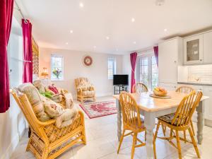 a kitchen and living room with a table and chairs at Paddock Barn in North Nibley