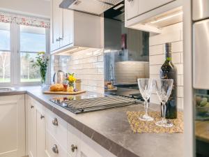 a kitchen with two wine glasses on a counter at Paddock Barn in North Nibley