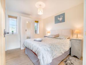 a bedroom with a large bed and a window at Paddock Barn in North Nibley +9 photos