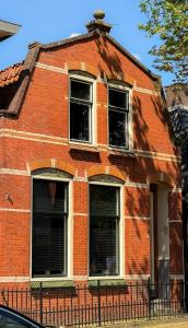 an old red brick building with two windows at luxe stadsappartement Workum in Workum