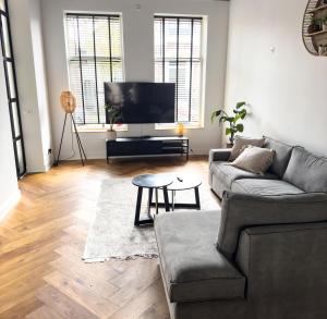 a living room with a couch and a flat screen tv at luxe stadsappartement Workum in Workum