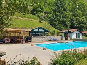 a swimming pool with a gazebo and a house at La maison d'Amatxi in Itxassou