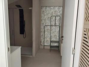 a hallway with a shower and a window with a chair at La maison d'Amatxi in Itxassou