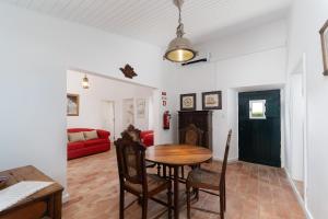 a living room with a table and a red couch at Quinta de Loubite by Sweethomes in Lagoa