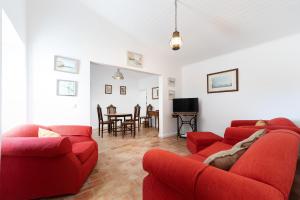 a living room with two red couches and a table at Quinta de Loubite by Sweethomes in Lagoa