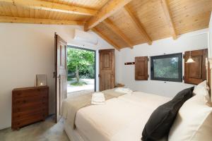 a bedroom with two beds and a window at Quinta de Loubite by Sweethomes in Lagoa +112 photos