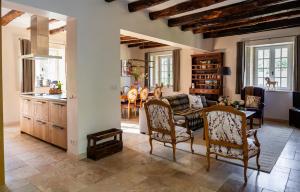a kitchen and living room with a table and chairs at Maison du Cèdre in Auriac-du-Périgord
