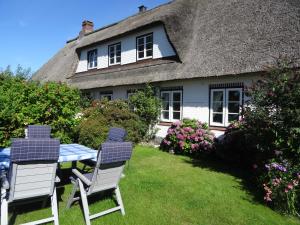 a table and chairs in front of a thatched house at Luckow Georg Asmussen Haus in Pommerby