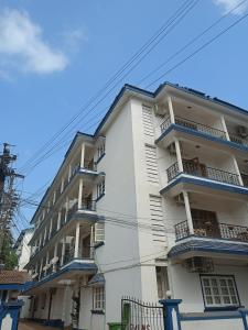 a white building with blue balconies on a street at Kukus nest blue in Jāmb