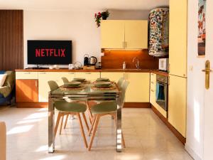 a kitchen with a glass table and chairs in it at La Terrasse Bleue-Parking couvert-2 min plage-Juan Les Pins in Antibes
