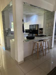 a kitchen with white cabinets and a table and chairs at Royaltics Lumina house in Weltevredenpark