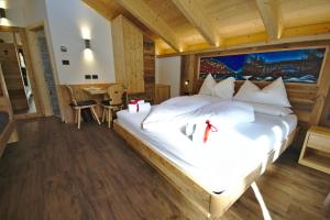 ein Schlafzimmer mit einem großen weißen Bett in einem Zimmer in der Unterkunft Agritur Maso Piasina in Tesero
