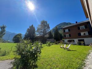 two chairs sitting in the grass next to a building at Apartment Kanisfluh in Mellau