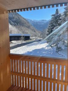 a window with a view of a snow covered mountain at Apartment Kanisfluh in Mellau +38 photos