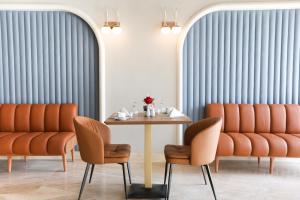 a dining room with orange chairs and a table at Occidental Cairo Grand Museum in Cairo