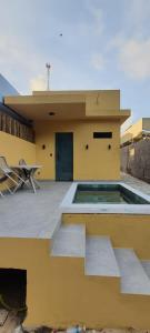 a yellow building with a swimming pool on a patio at Dream House Hospedagens in Itacimirim