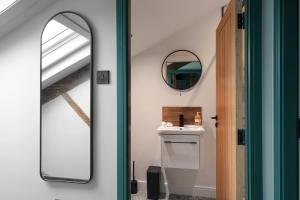 a bathroom with a mirror next to a sink at Royal Six Apartments in Harrogate
