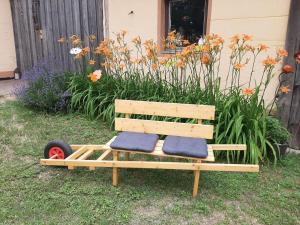 a wooden bench with blue cushions sitting in a yard at Ferienhaus Bayerlipp in Scheßlitz +49 photos