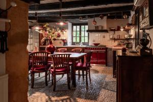 a kitchen with a table and chairs in it at La ferme du coustal in Vialot