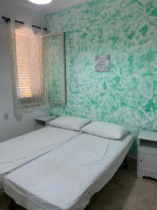 a bedroom with a bed and a green wall at Delfino in Letojanni