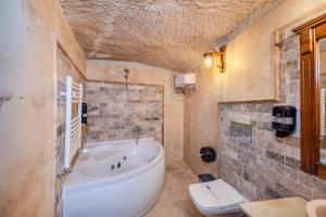 a bathroom with a tub and a toilet in it at Stone House Cave Hotel in Göreme +107 photos