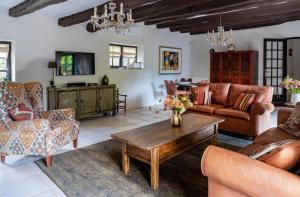 a living room with leather furniture and a coffee table at La ferme du coustal in Vialot