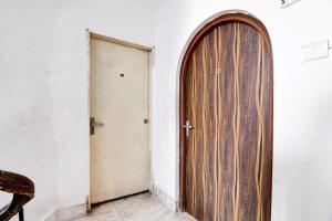a large wooden door in a room with a doorway at Hotel O Avenue Villa in Dum Dum