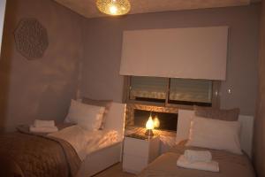 マラケシュにあるPrestigia Golf City Apartmentの小さなベッドルーム(ベッド2台、窓付)